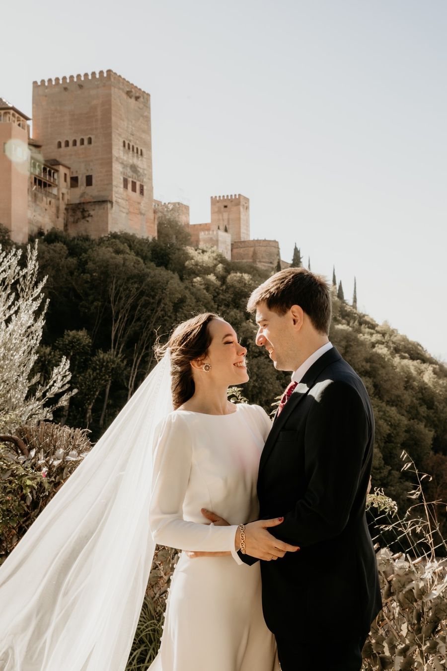 Novios abrazados con la Alhambra de Granada detrás