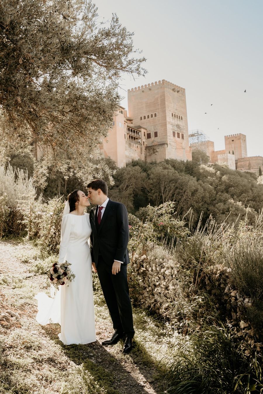 Beso de los novios en el camino bajo la Alhambra