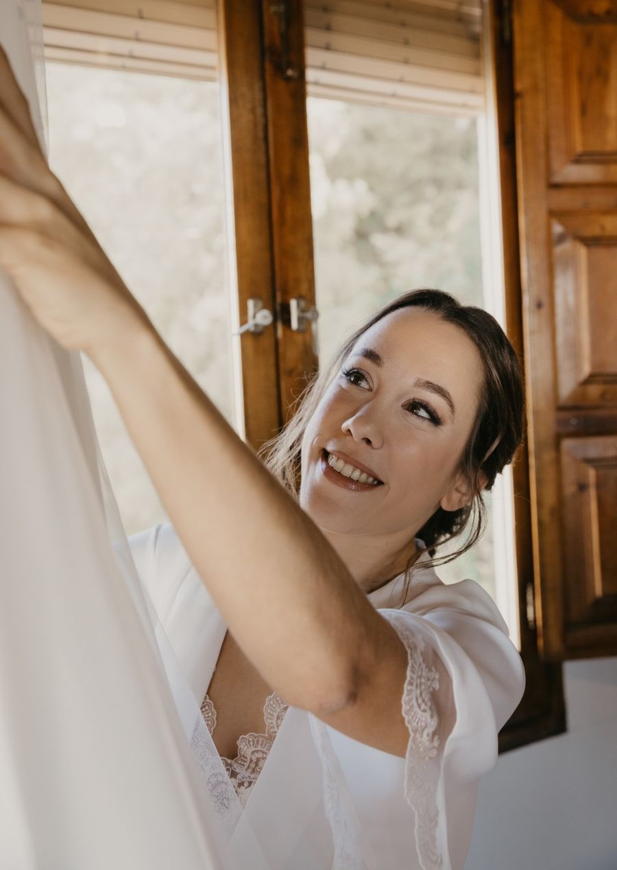 Novia sonriendo mientras recoge el vestido