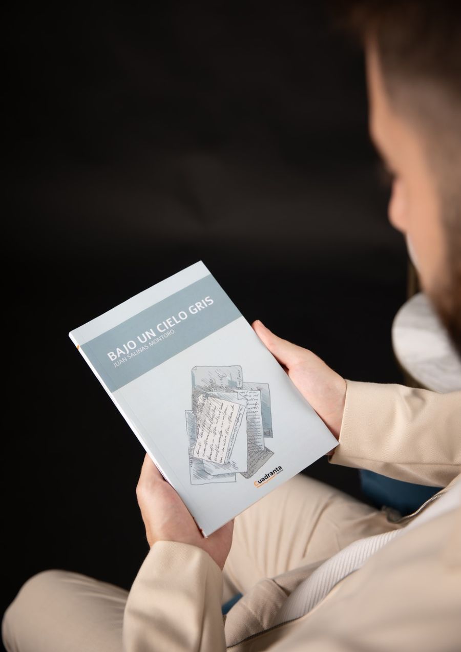 Lector sosteniendo el libro Bajo un cielo gris