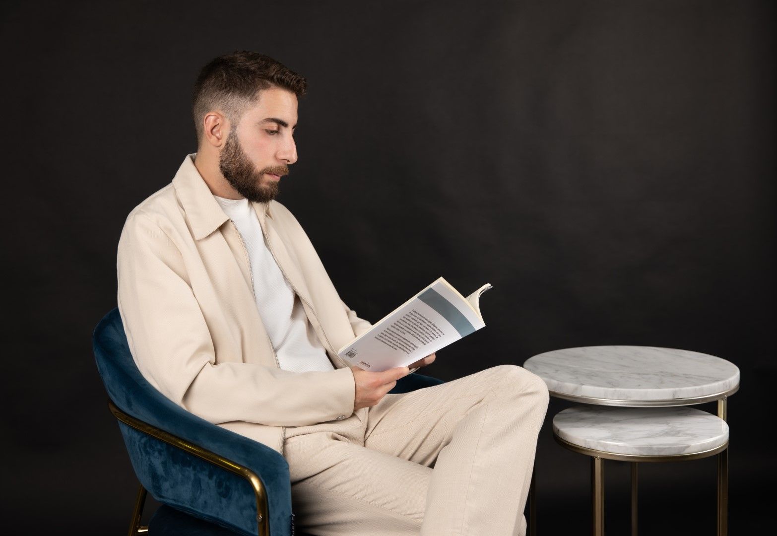 Hombre leyendo sentado en un sillón azul