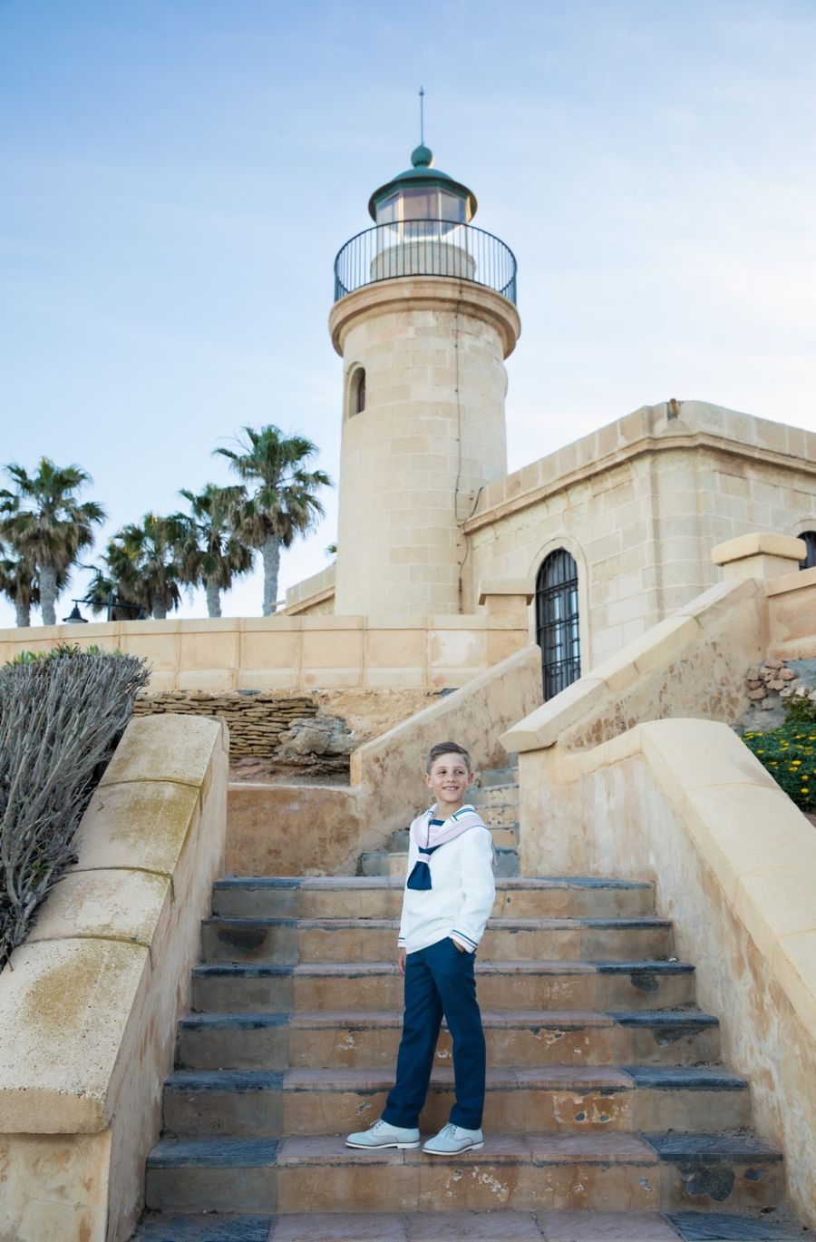 Niño de comunión en la escalinata del faro