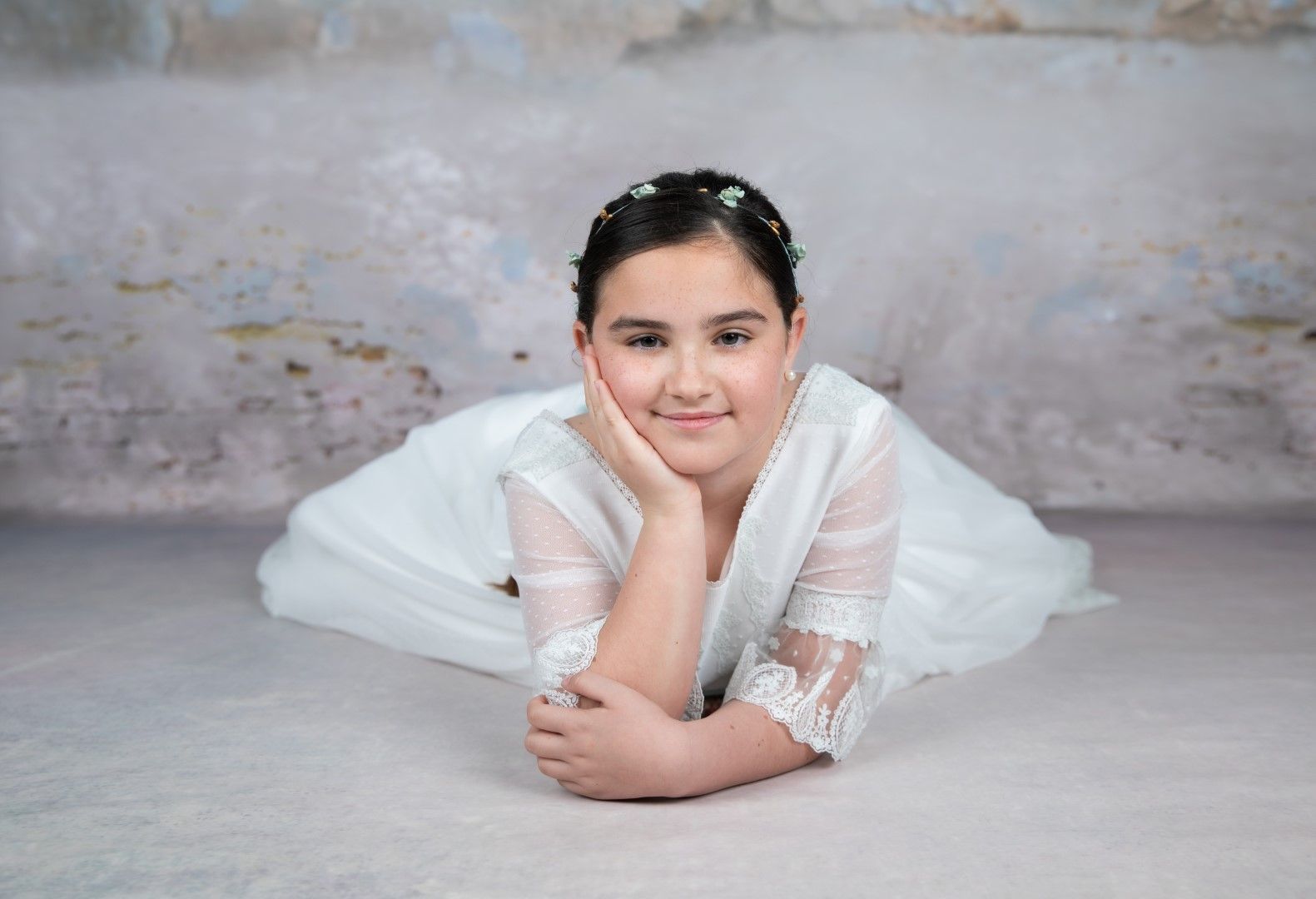 Niña de comunión tumbada en el estudio
