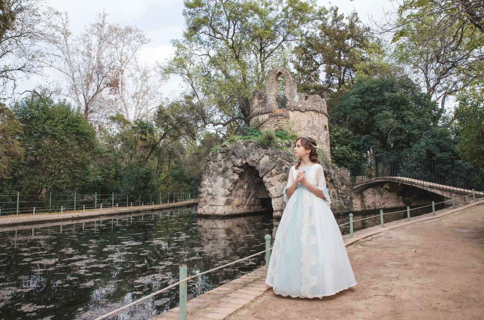 Niña de comunión junto al estanque del parque