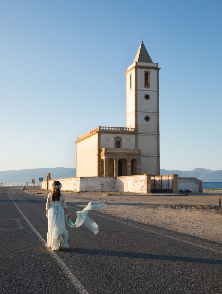 Niña de comunión en la carretera frente a la iglesia junto al mar