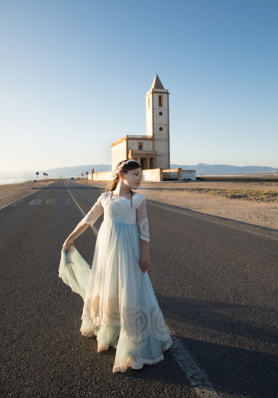 Niña de comunión con la iglesia al fondo