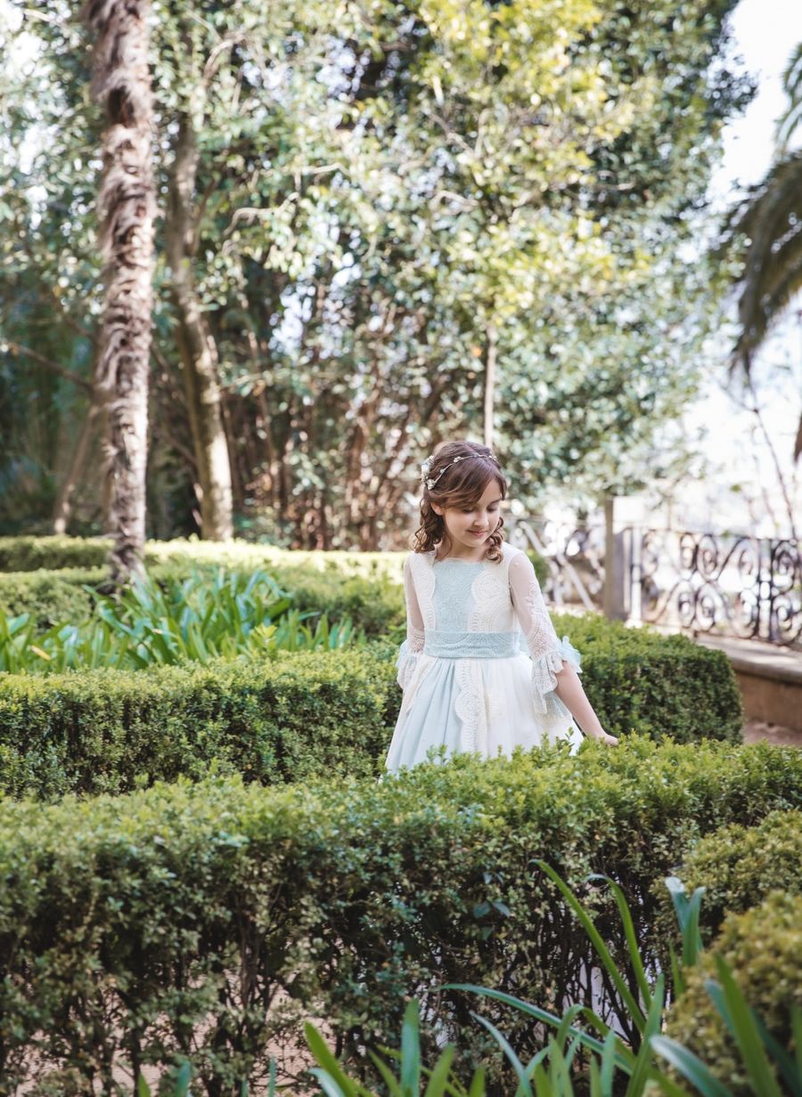 Niña de comunión en un jardín