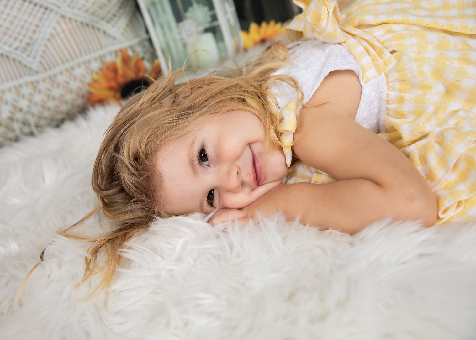 Niña sonriendo tumbada sobre una manta de pelo