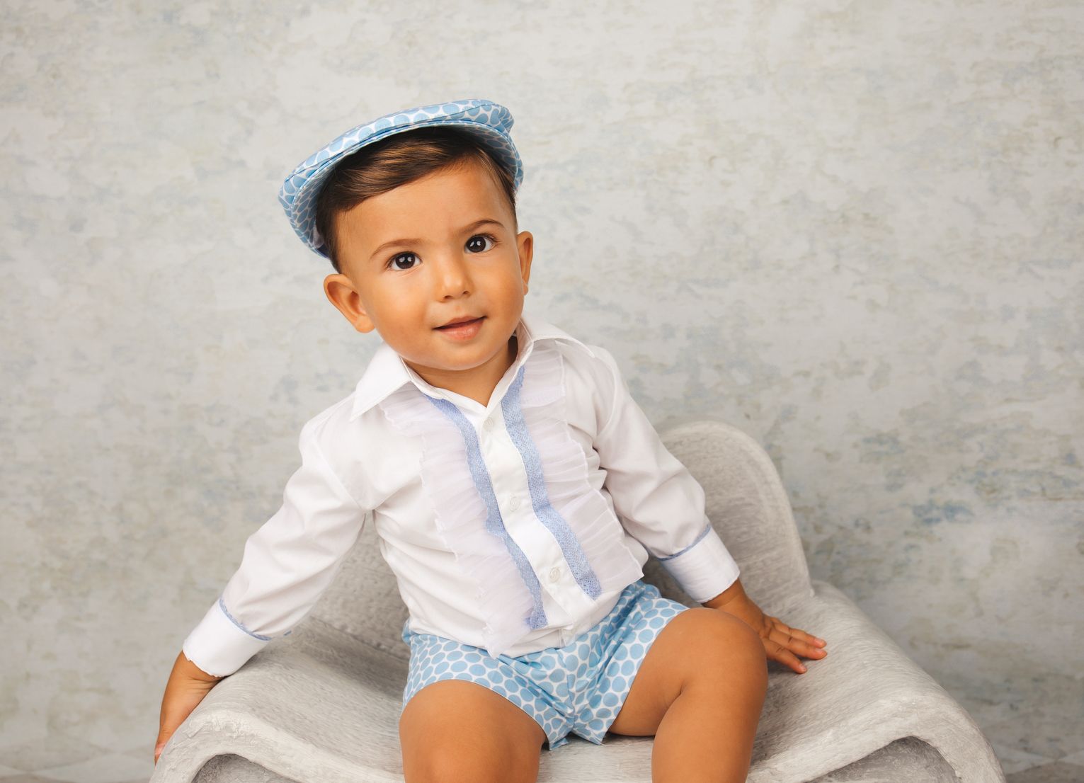 Niño con gorra sentado en el estudio