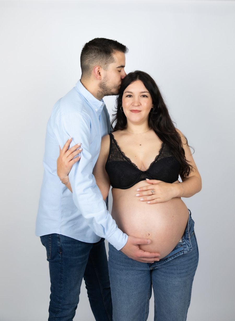 Pareja abrazada en el estudio durante el embarazo