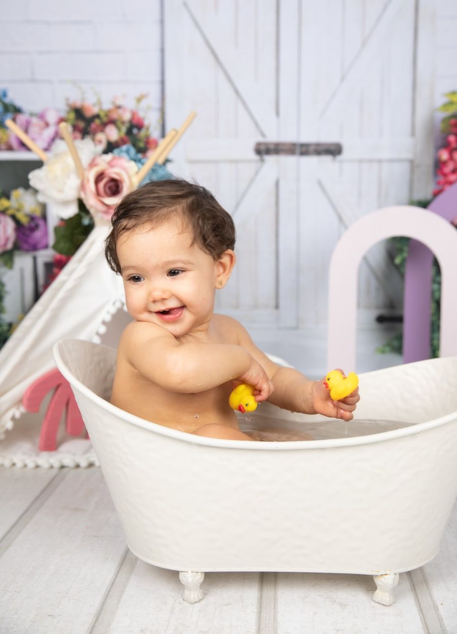 Bebé jugando en una bañera con un patito