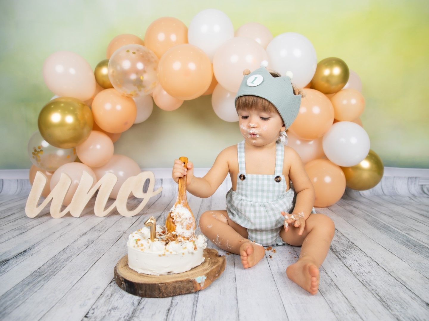 Bebé con corona y la tarta del primer cumpleaños